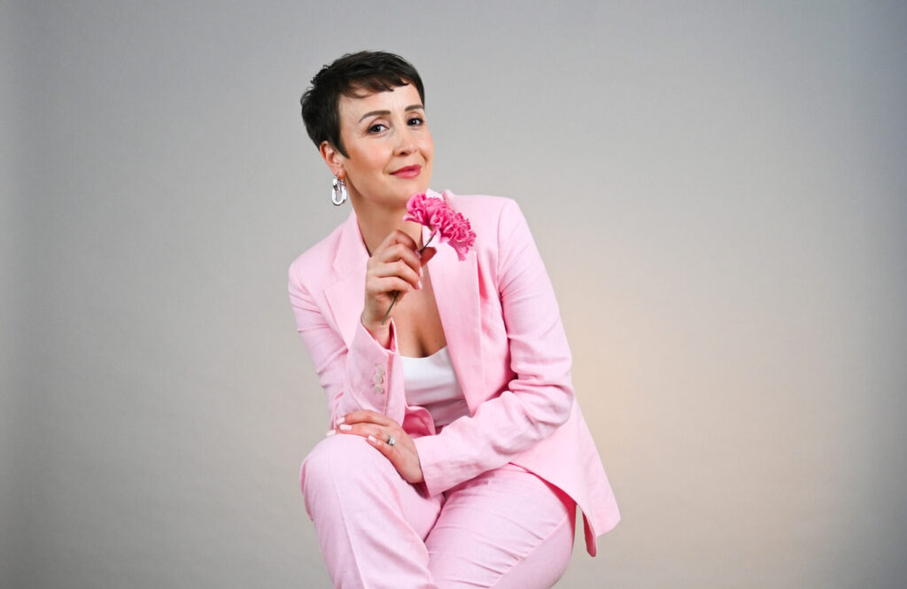 Elif Köse the editor of Confidence Magazine in a Pink Suit in a studio